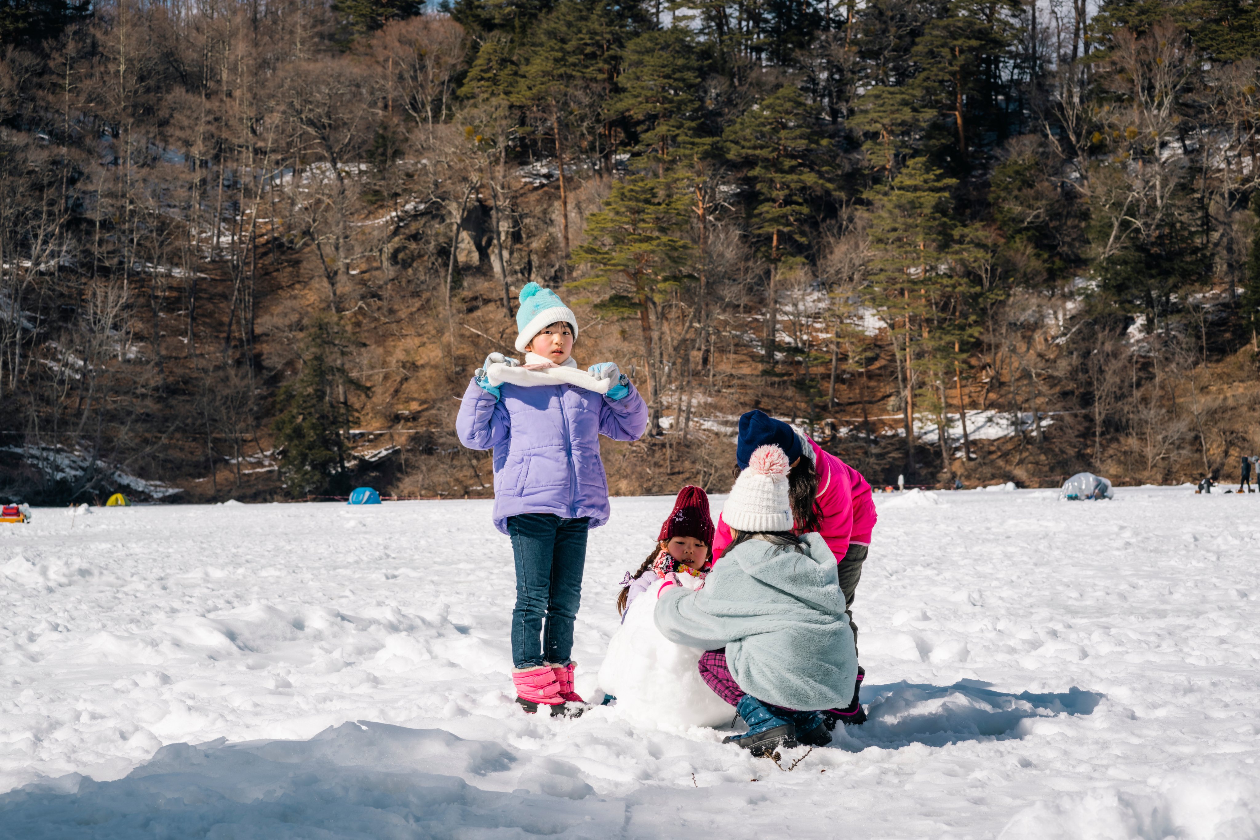 冬の雪景色の中で遊ぶ子ども